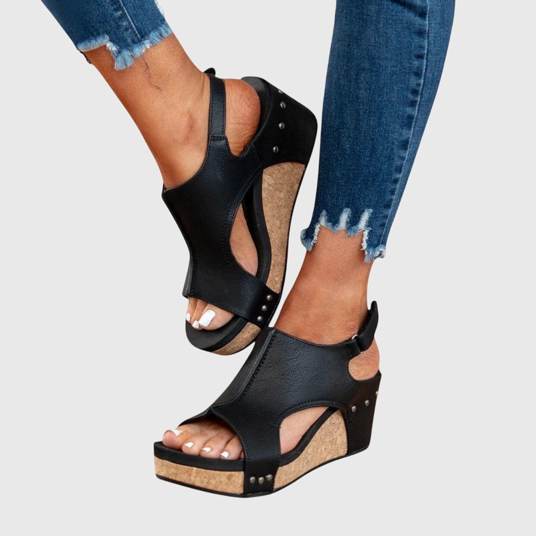 A woman in taupe wedge sandals with an open front, out shopping on a warm day.
