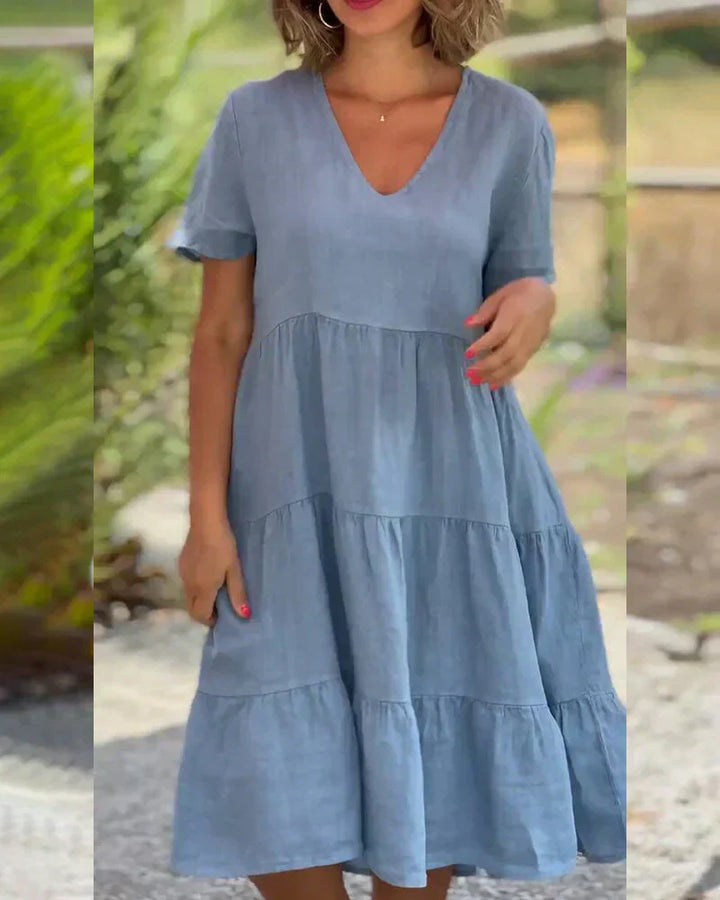 Woman wearing the Bonnie™ V-neck summer dress with a soft layered skirt, strolling on a sunny afternoon.