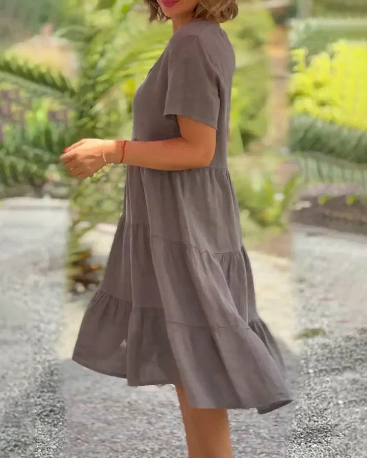 Woman wearing the Bonnie™ V-neck summer dress with a soft layered skirt, strolling on a sunny afternoon.