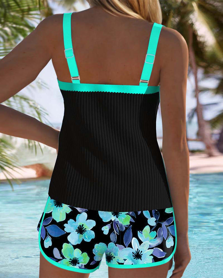 A woman at the water's edge in a bright printed two-piece tankini, relaxed and confident.