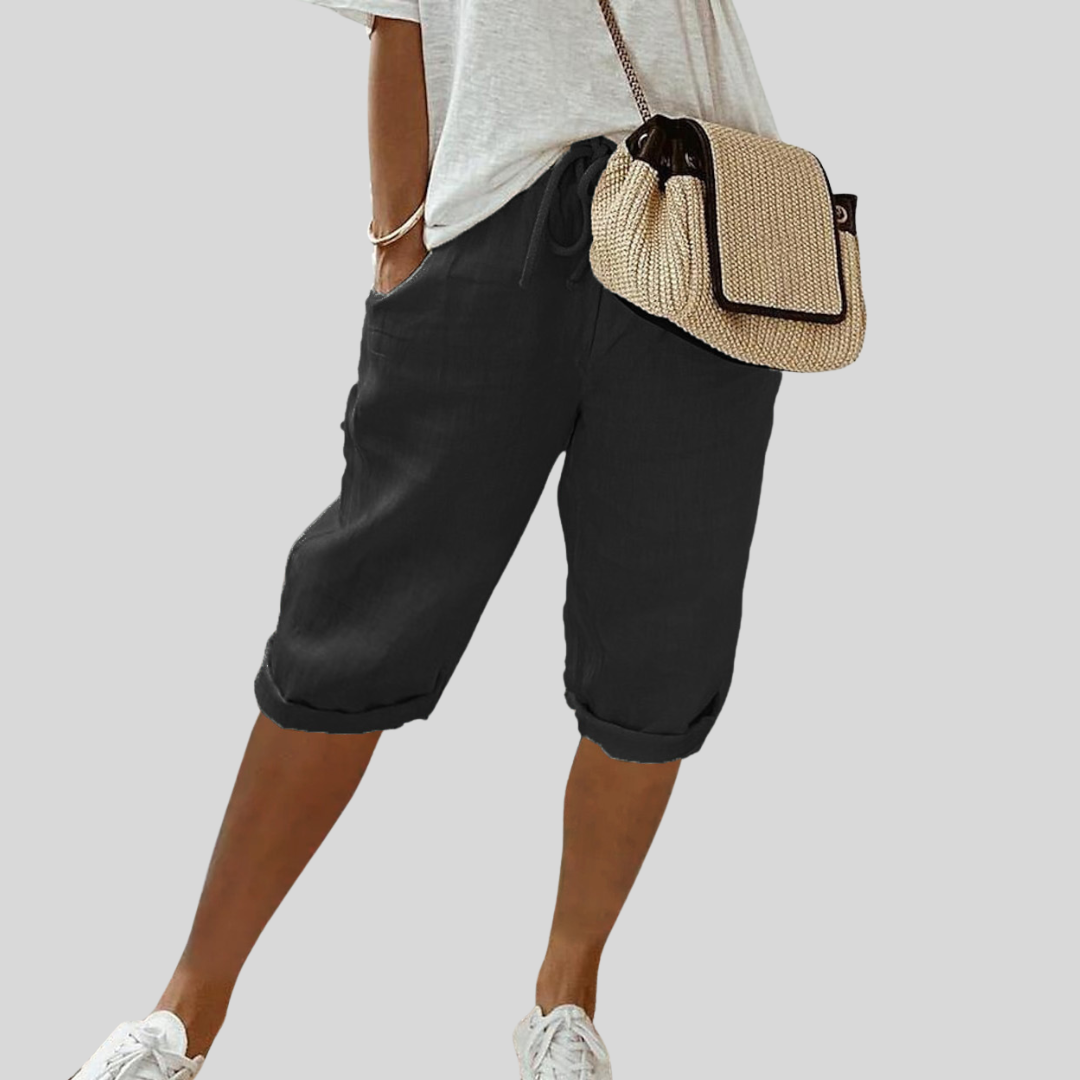 A woman wearing elegant flowing shorts with a soft elastic waist and deep pockets.