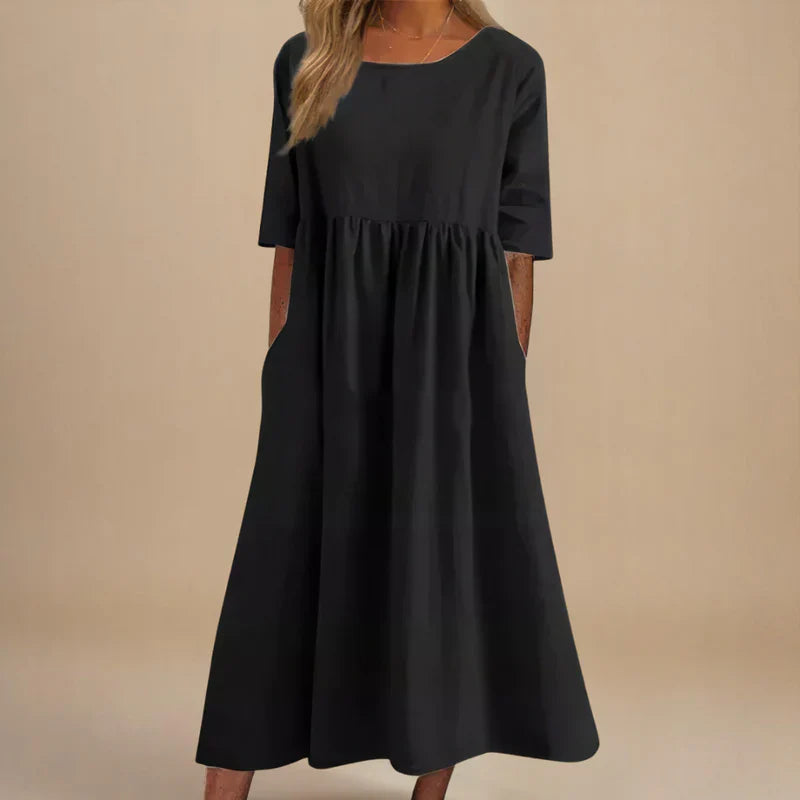 A woman wearing the Shannon flowing day dress with a gathered waist and elbow-length sleeves.