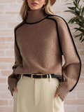 A woman wearing a funnel neck sweater with contrast piping, styled with pants for a smart-casual look.