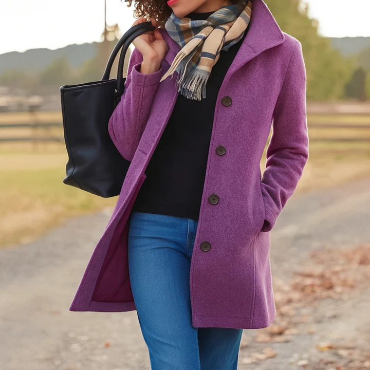 A woman wearing an elegant camel button-through coat over a sweater on a crisp fall day.
