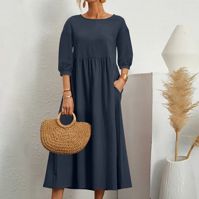 A woman wearing the Barbara fitted waist midi dress with three-quarter sleeves and a flowing skirt.