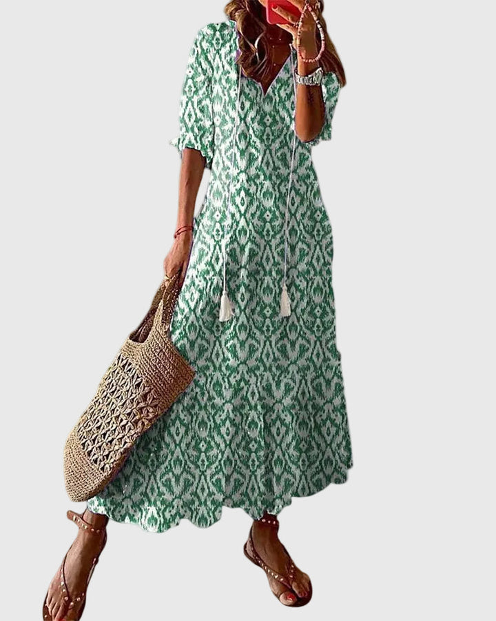 Woman wearing a long vintage-style boho maxi dress with delicate patterns and a fluttering V-neckline.