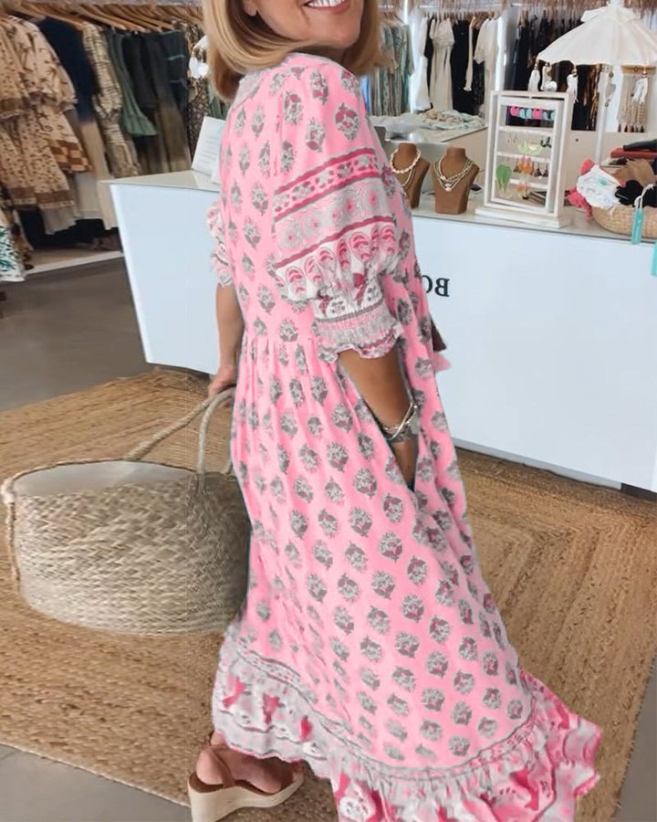 A woman wearing the Tracy boho floral midi dress with a fringed neckline and ruffled skirt.