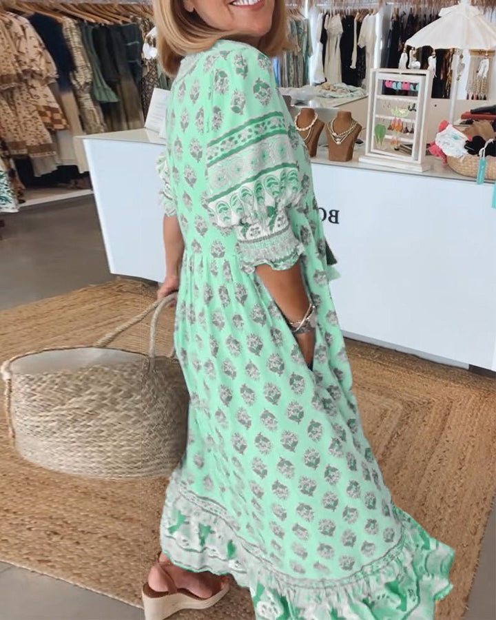 A woman wearing the Tracy boho floral midi dress with a fringed neckline and ruffled skirt.
