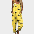 A woman smiling in bright yellow bee-print overalls with a relaxed fit and adjustable straps.