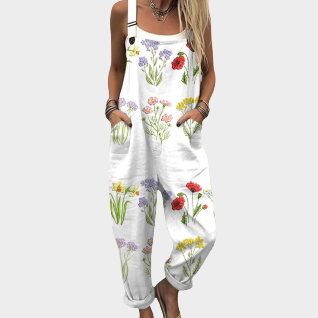 Woman wearing white overalls printed with a colourful wildflower meadow of poppies and daisies