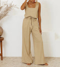 A woman wearing a minimal two-piece set with a square neckline and belted flared pants.