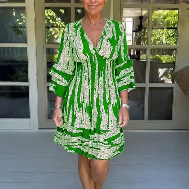 Woman wearing a boho print mini dress with ruffled sleeves and a soft V-neckline.