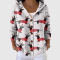A woman wearing a white hooded button cardigan printed with dachshunds in red sweaters and antlers.