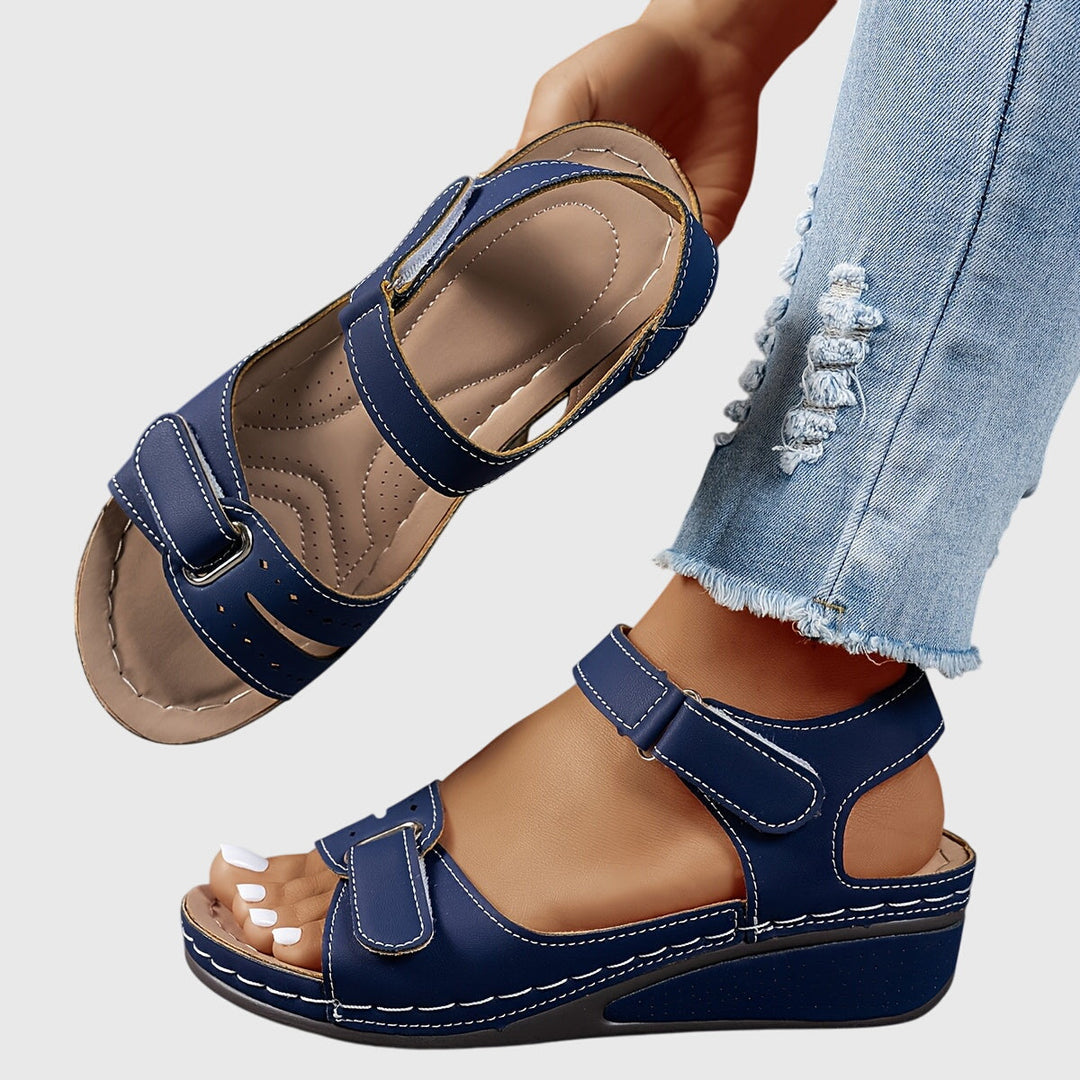 A woman wearing wide-fit supportive sandals with a relaxed summer outfit, walking with ease and confidence.
