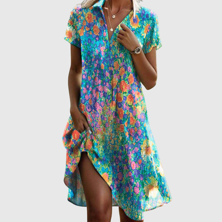 Woman wearing the Cynthia speckled summer dress in green, smiling in the sunshine outdoors.