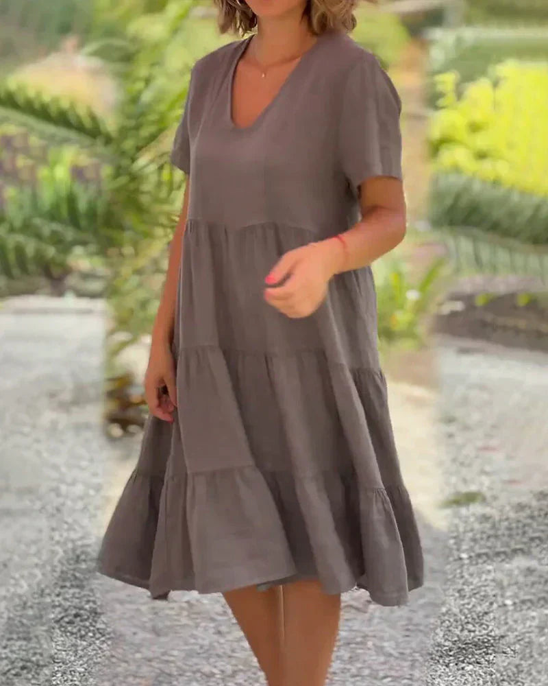 Woman wearing the Bonnie™ V-neck summer dress with a soft layered skirt, strolling on a sunny afternoon.