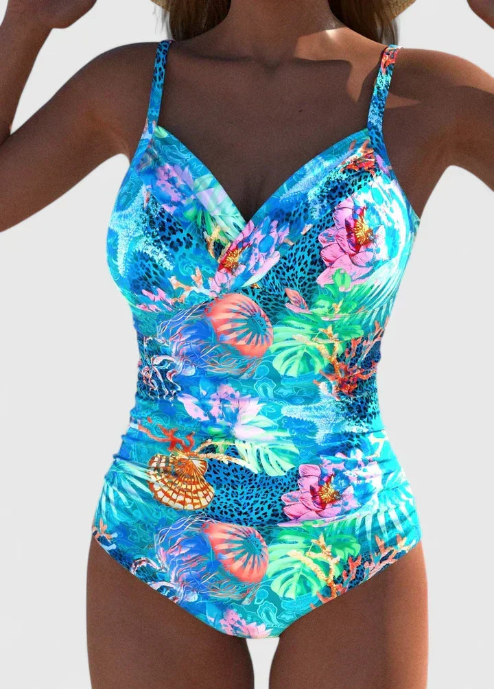 A woman wearing an elegant swimsuit with a fresh print, confident and relaxed by the water.