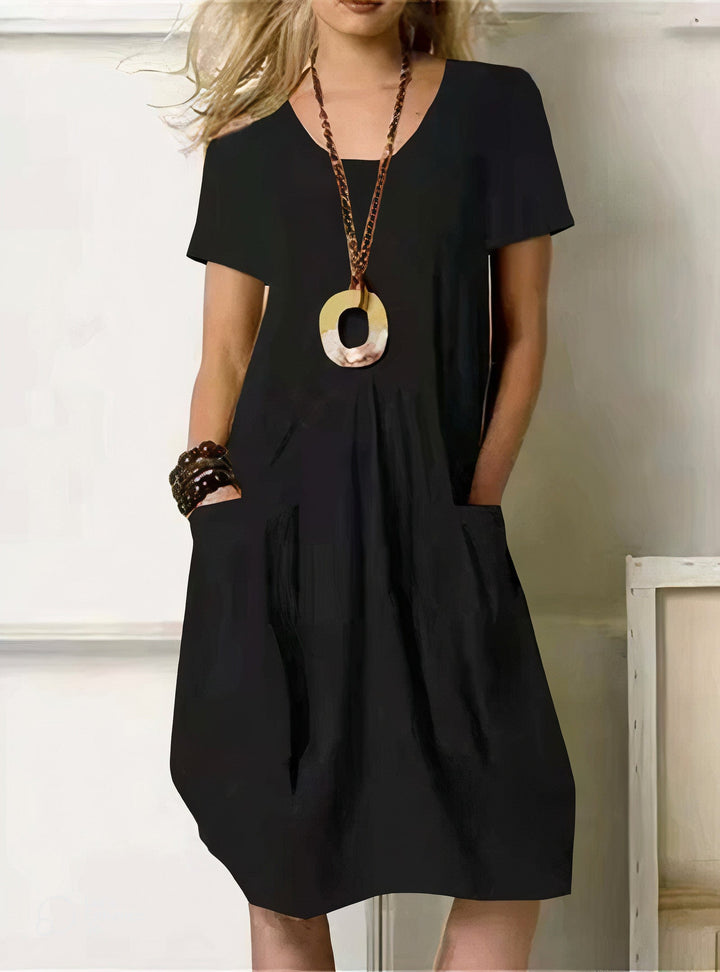 Woman wearing the Paula™ A-line midi dress with pockets and a round neckline, out on an everyday errand.