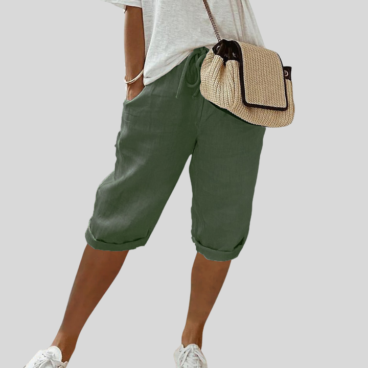 A woman wearing elegant flowing shorts with a soft elastic waist and deep pockets.