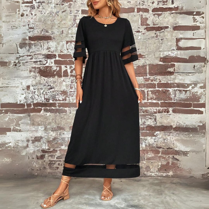 Woman wearing the Colleen™ empire waist midi dress with a flowing skirt and round neckline at a family gathering.