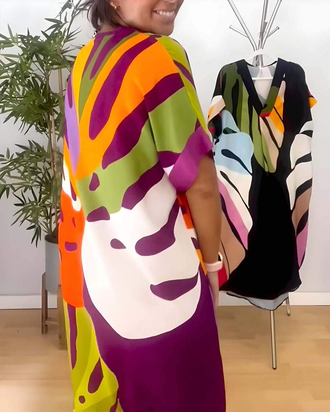 A woman wearing a colourful abstract print dress with a V-neckline and short sleeves.