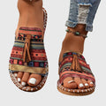 A woman wearing colourful patterned boho slides with tassel details on a holiday day out.