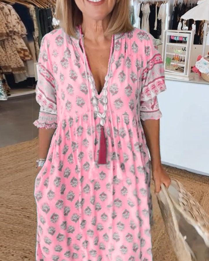 A woman wearing the Tracy boho floral midi dress with a fringed neckline and ruffled skirt.