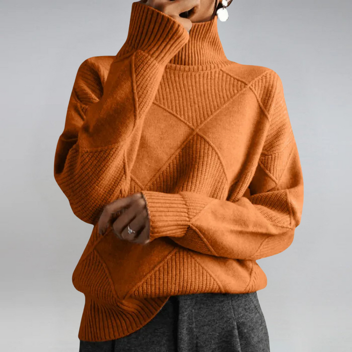 A woman in a stand-collar sweater with an elegant drape, styled with tailored pants.