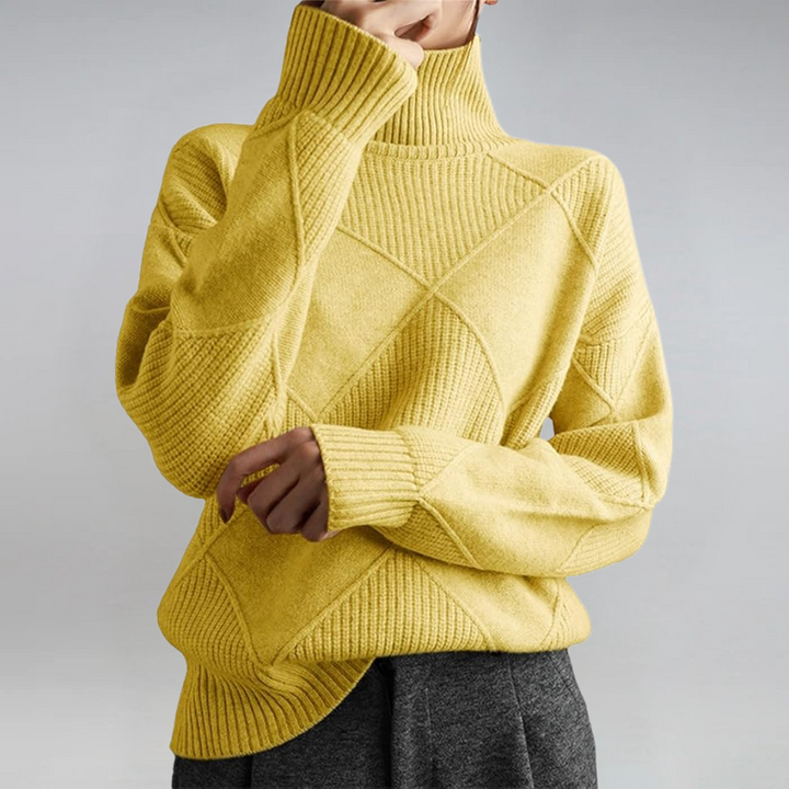 A woman in a stand-collar sweater with an elegant drape, styled with tailored pants.