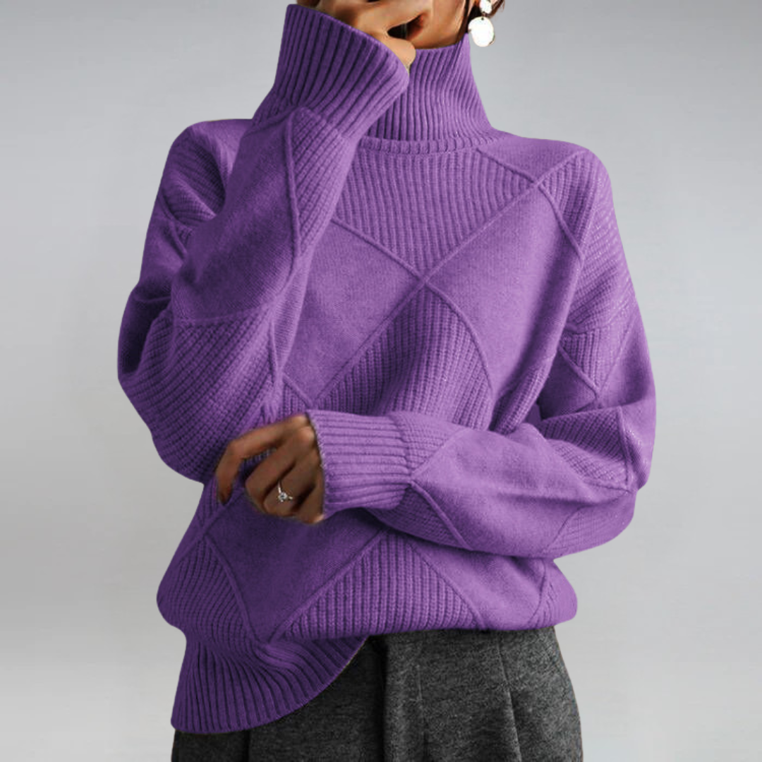 A woman in a stand-collar sweater with an elegant drape, styled with tailored pants.