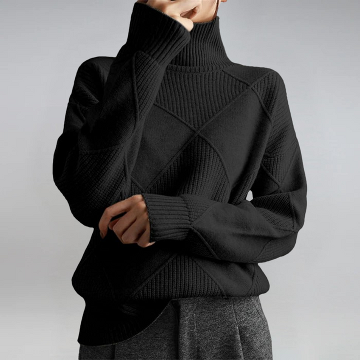 A woman in a stand-collar sweater with an elegant drape, styled with tailored pants.