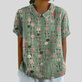 A woman wearing a flowing floral top with a refined collar on a relaxed morning outing.