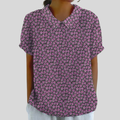 A woman wearing a soft floral top with a fine collar, confident and comfortable on a day out.