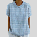 A woman wearing a blue gingham check top with a polo collar on a relaxed day out