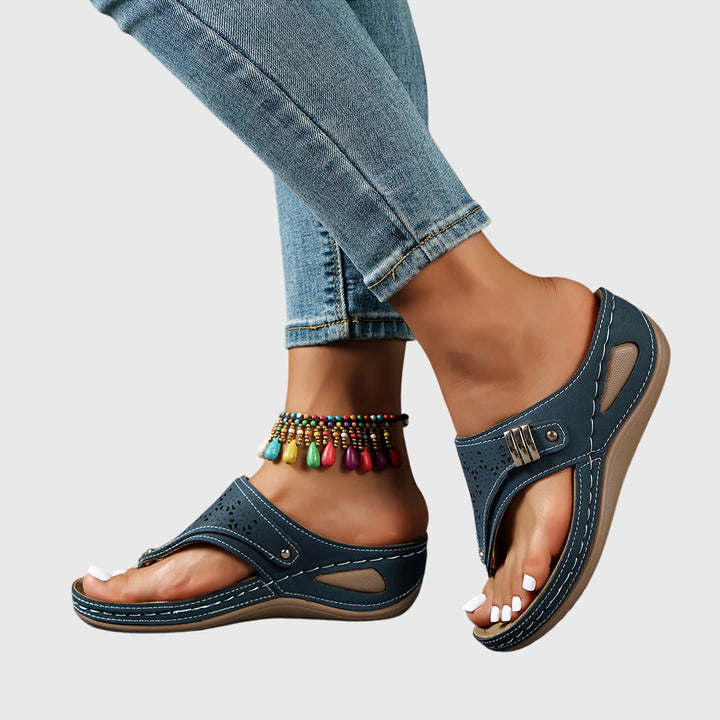 A woman in grey comfort flip-flops relaxing outdoors, feet cushioned and supported.