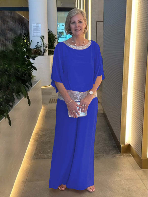 A woman wearing an embellished blouse-style top with softly flowing wide evening pants.