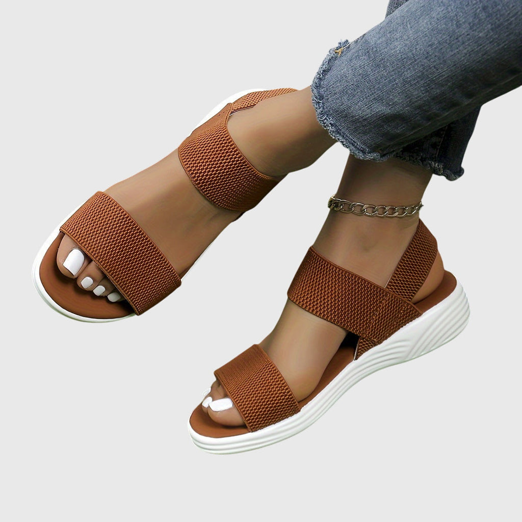 Black open-toe everyday sandals with wide stretch straps and a thick cushioned sole.