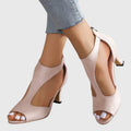 A woman wearing flexible orthopaedic heels, standing comfortably in a polished everyday outfit.