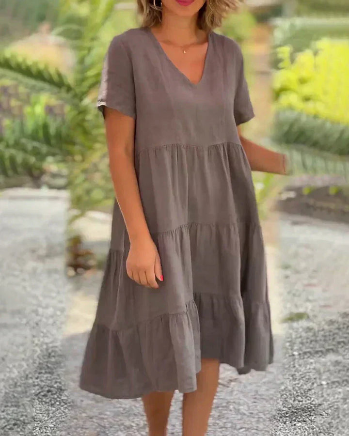 Woman wearing the Bonnie™ V-neck summer dress with a soft layered skirt, strolling on a sunny afternoon.