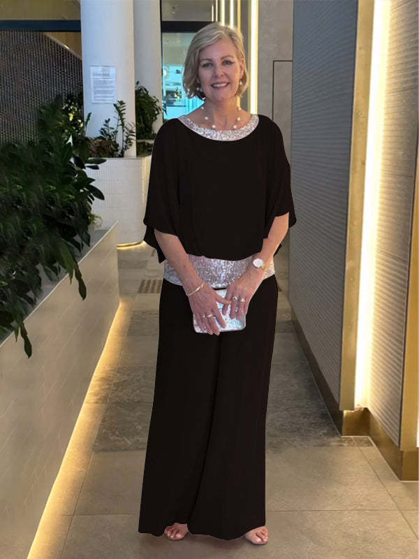 A woman wearing an embellished blouse-style top with softly flowing wide evening pants.