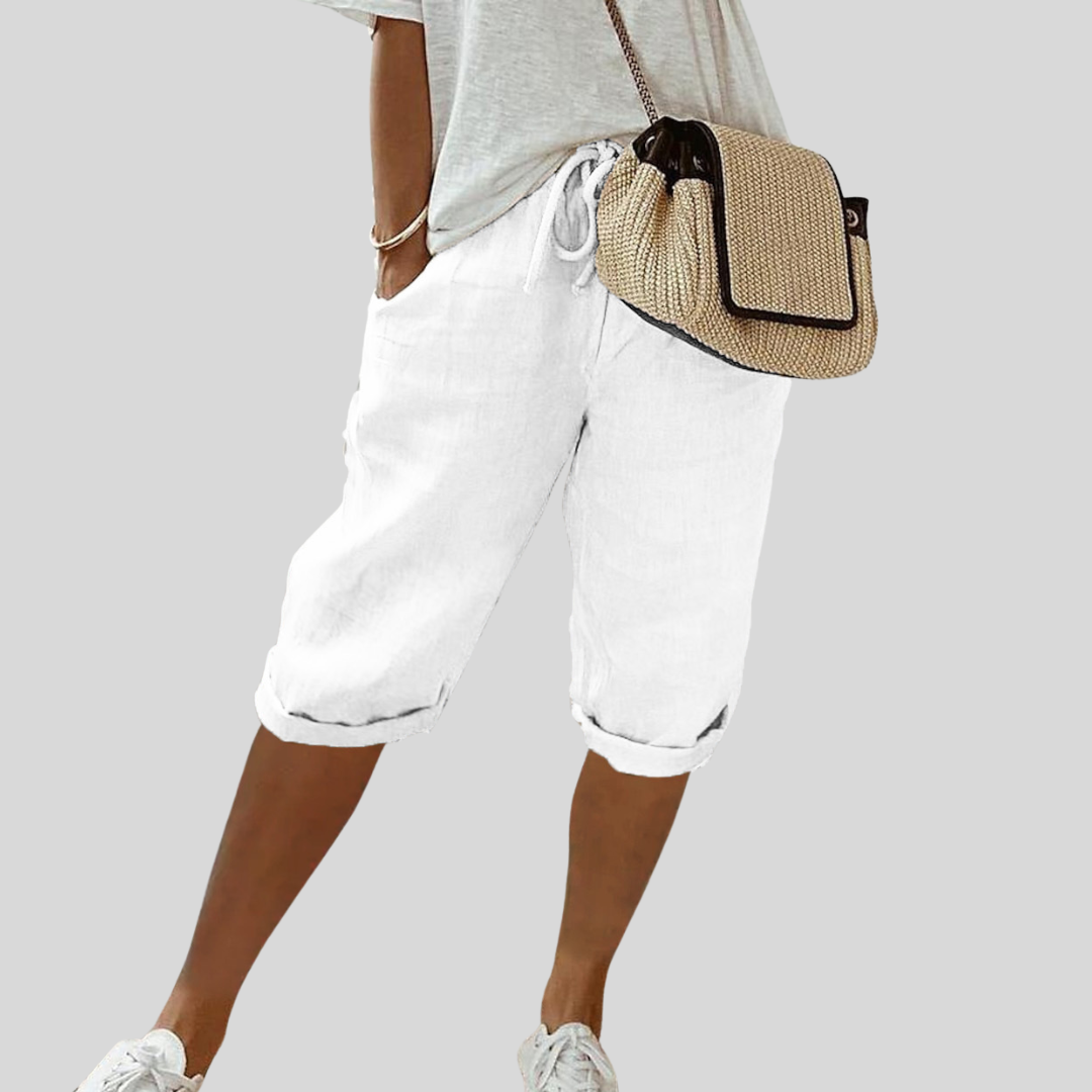 A woman wearing elegant flowing shorts with a soft elastic waist and deep pockets.