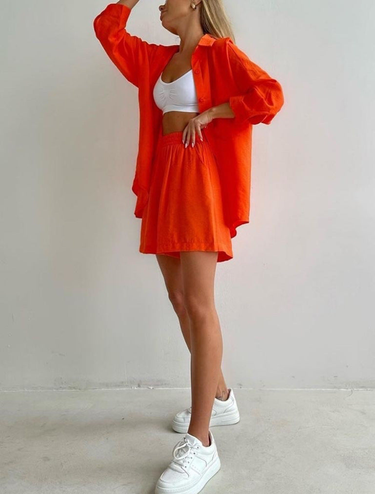 A woman wearing an oversized button-up shirt with matching high-waisted shorts.