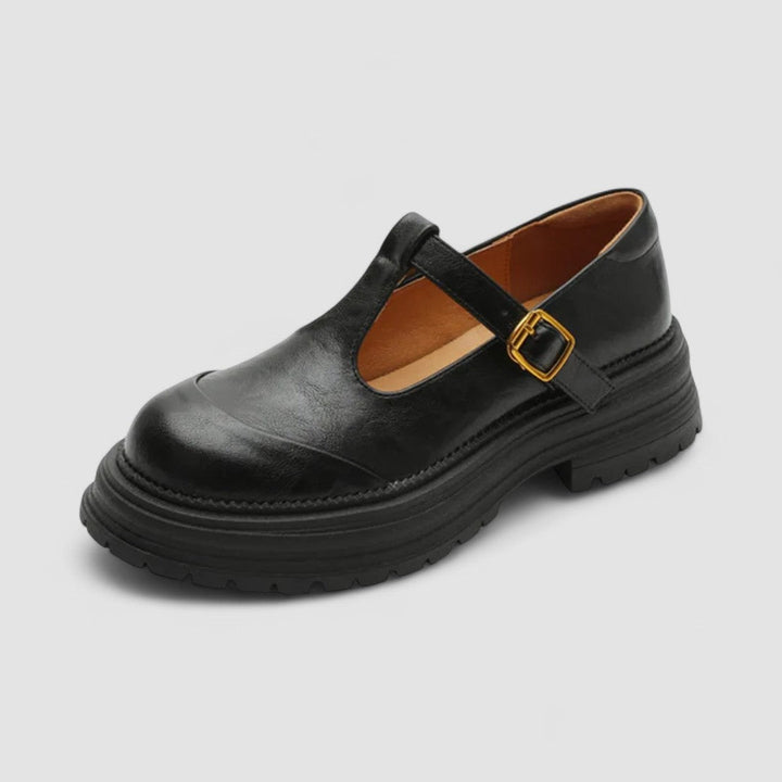 Woman wearing brown Mary Stacey comfort shoes with a T-strap, standing on a city footpath.