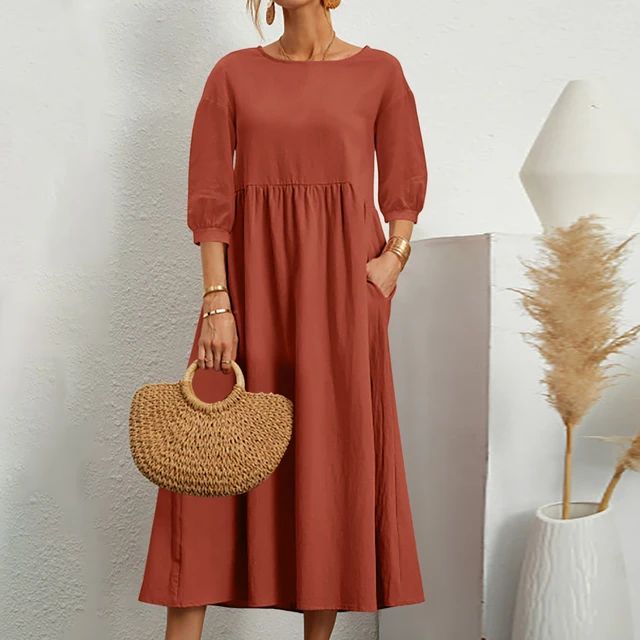 A woman wearing the Barbara fitted waist midi dress with three-quarter sleeves and a flowing skirt.