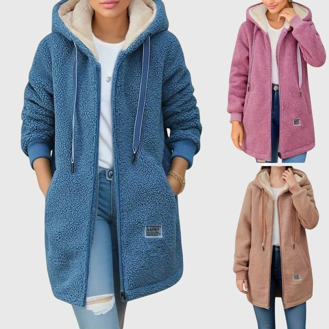 A woman wearing a cosy hooded jacket wrapped up warm on a cold winter morning.