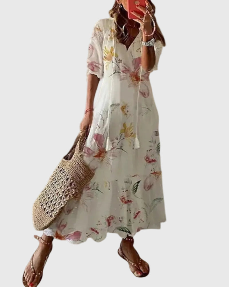 Woman wearing a long vintage-style boho maxi dress with delicate patterns and a fluttering V-neckline.