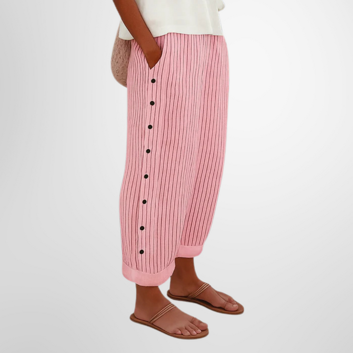 A woman wearing elegant everyday pants in a fine blue stripe with a wide cut and side buttons.