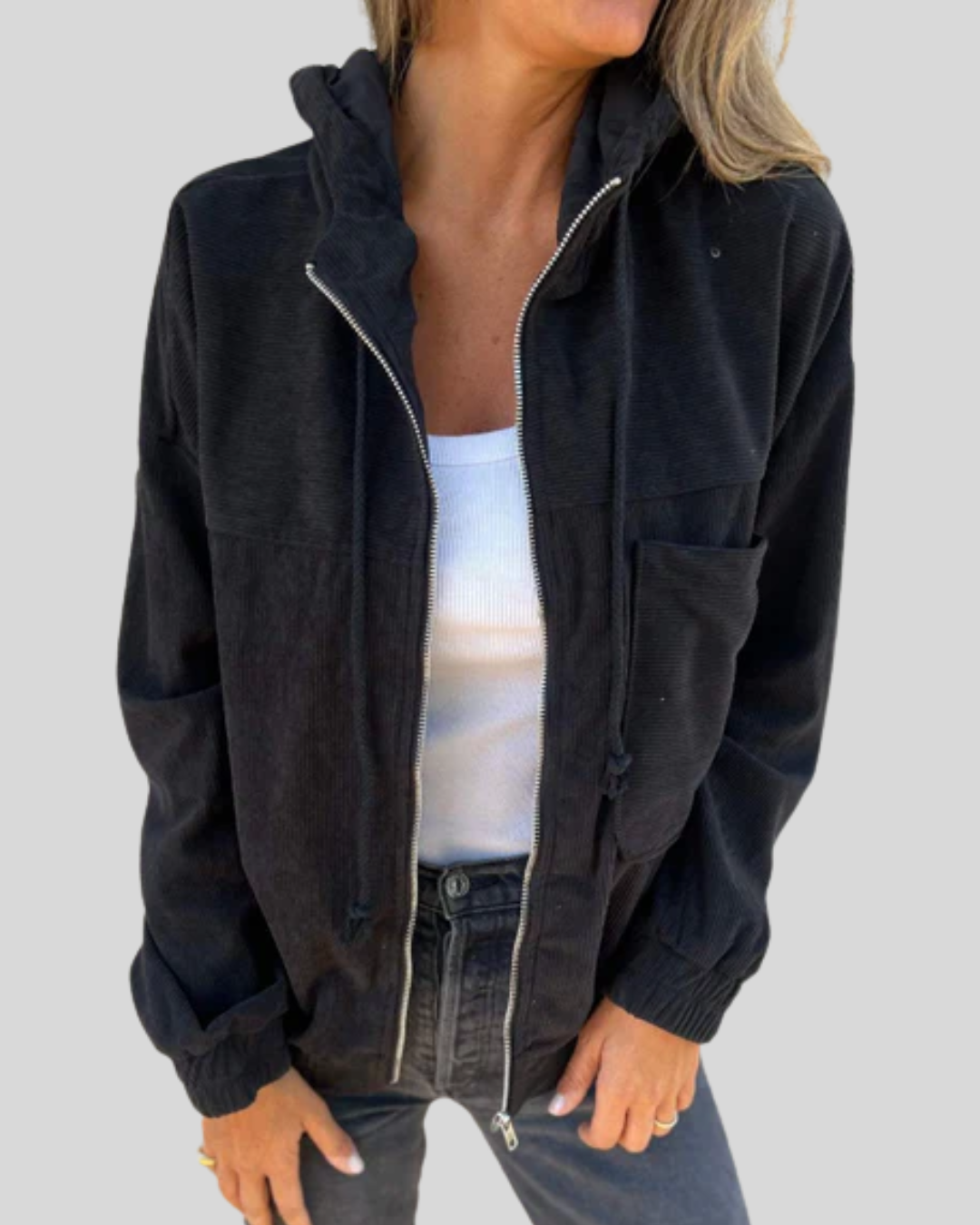 A woman wearing a blue zip-up hooded jacket with a soft ribbed texture and long sleeves.