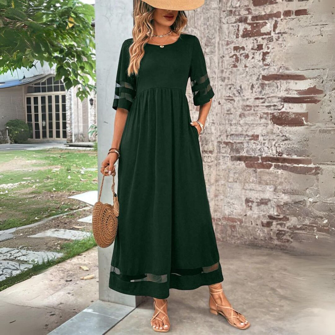 Woman wearing the Colleen™ empire waist midi dress with a flowing skirt and round neckline at a family gathering.