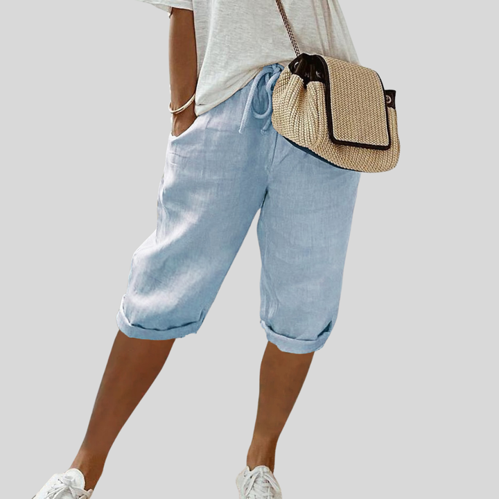 A woman wearing elegant flowing shorts with a soft elastic waist and deep pockets.